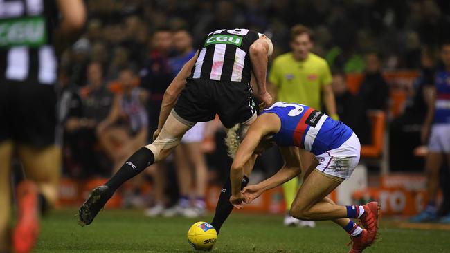 Mason Cox of the Magpies bumps Jason Johannisen of the Bulldogs. Picture: AAP.