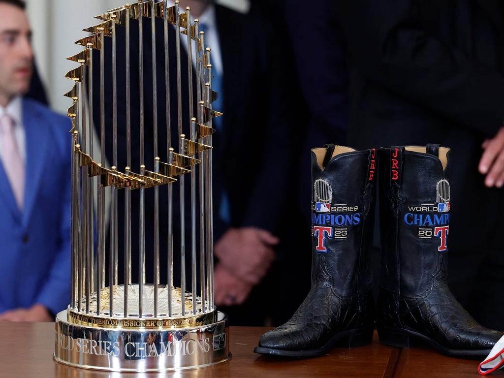 The Major League Baseball Commissioners Trophy sits next to a custom made pair of cowboy books, a gift for US President Joe Biden. Picture: Getty Images via AFP