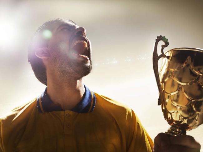 Athlete holding trophy cup in stadium