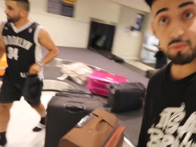 Saleh’s friends stand at the luggage carousel in Sydney airport where they claim to be waiting for him to arrive in a suitcase. Picture: YouTube: Adam Saleh Vlogs