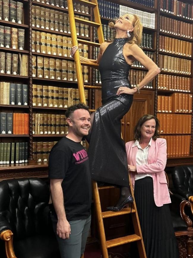 Musical theatre star Rhonda Burchmore (on ladder), Wynnum Fringe's Tom Oliver (left), and Lytton MP Joan Pease in the members' reading room in Queensland parliament. Picture: Joan Pease.