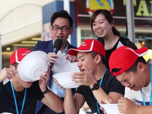 Kevin Tu, Ricky Tran and Long Kieu competing in the noodle eating competition at the Moon Festival in 2017. Picture: Carmela Roche.