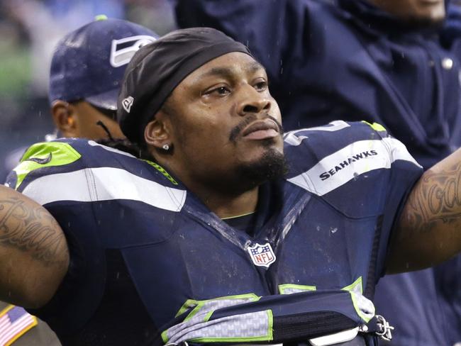 Seattle Seahawks running back Marshawn Lynch (24) signals a touchdown as Seahawks quarterback Russell Wilson runs for a touchdown against the New York Giants in the second half of an NFL football game, Sunday, Nov. 9, 2014, in Seattle. (AP Photo/Elaine Thompson)