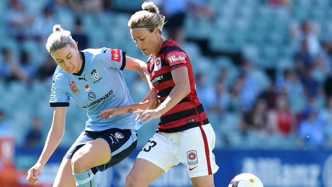 Joanne Burgess of the Wanderers (right) is tackled by Alana Kennedy of Sydney FC during their local derby.