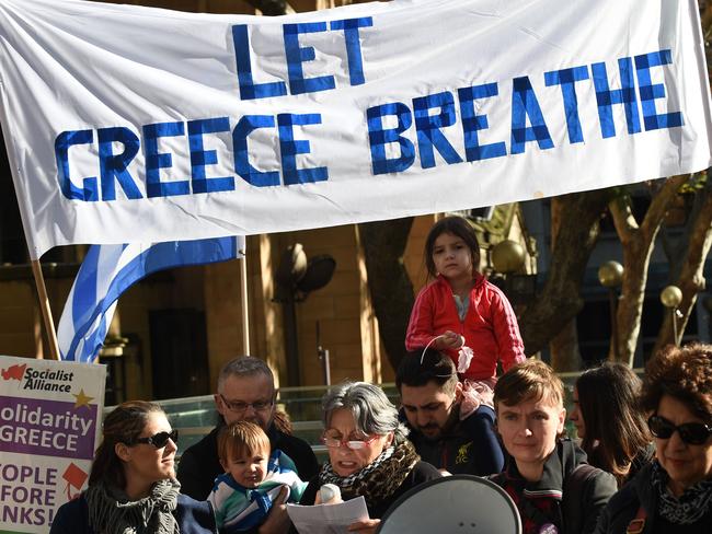 Greeks and their supporters gather holding banners in support of their countrymen in Sydney on July 4, 2015, a day before nearly 10 million Greek voters take to the ballot booths to vote 'Yes' or 'No' in a referendum asking if they accept more austerity measures in return for bailout funds. The referendum on a deal with European governments, the European Union (EU) and International Monetary Fund (IMF), was called by Prime Minister Alexis Tsipras on the night of June 26-27. Hundreds of people rallied in Australia in solidarity with Greeks ahead of the make-or-break weekend referendum. AFP PHOTO / Peter PARKS