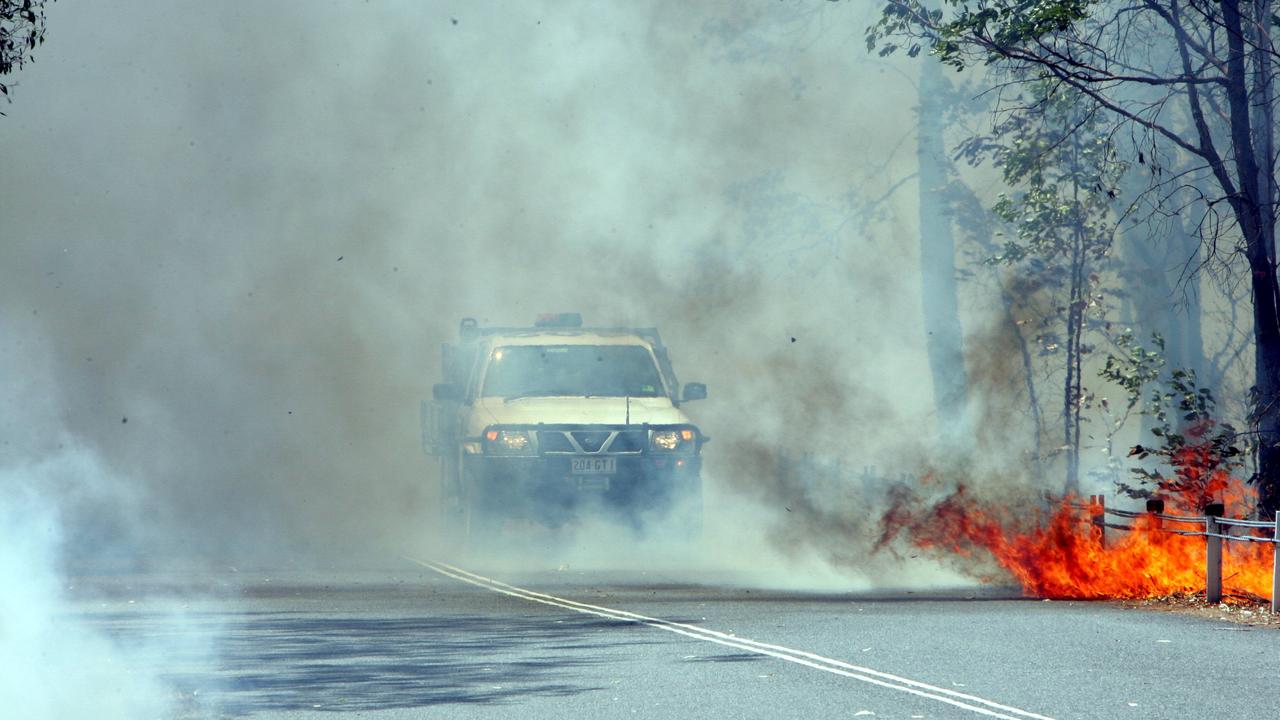 The Sir Samuel Griffith Drive is closed as the fire crosses the road.