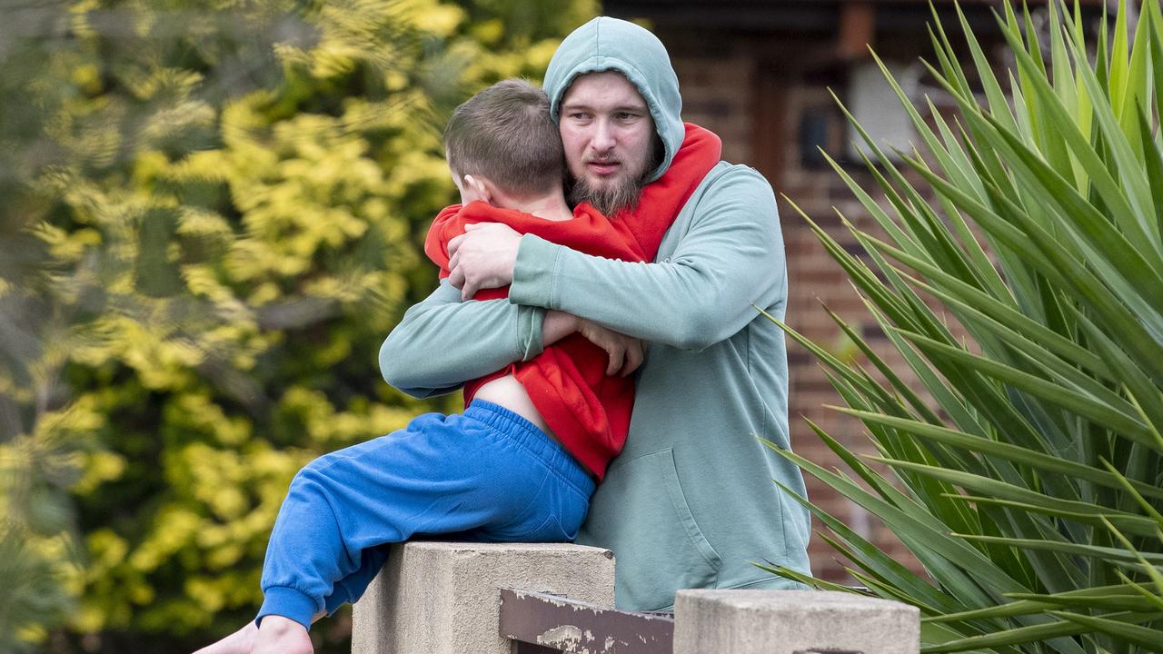 Neighbour Jarrod Hawkins - pictured hugging his son - went into the burning home in an attempt to save residents. Picture: NewsWire / Simon Bullard.