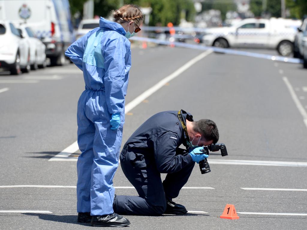 Detectives assess a bullet casing near the scene. Picture: NewsWire / Andrew Henshaw