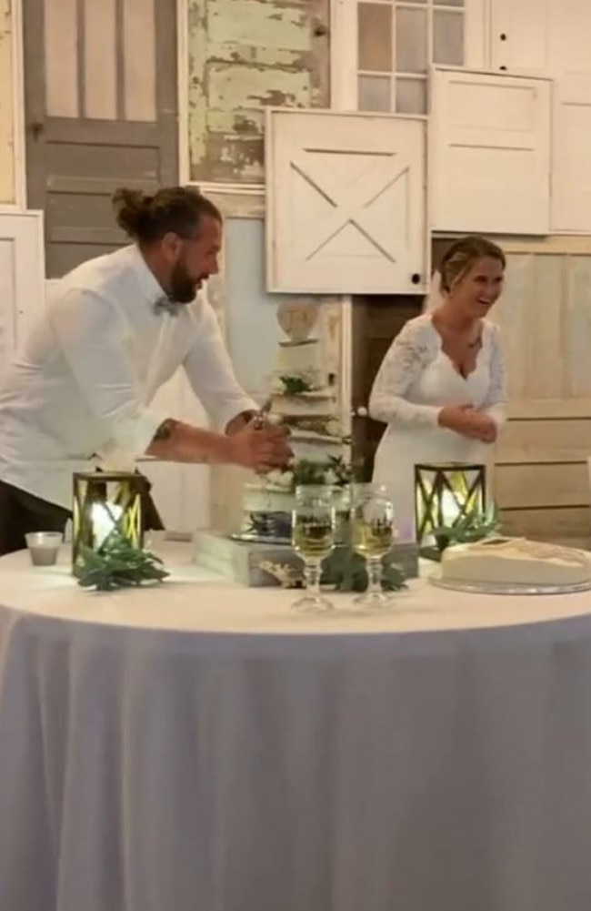 He then grabs their entire three-teir wedding cake. Picture: TikTok/kelsboyd3