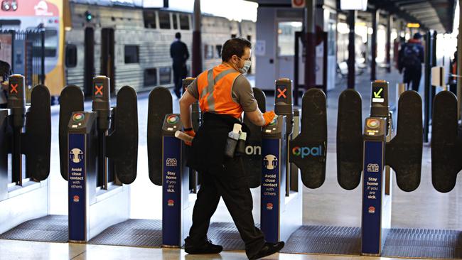 A NSW transport worker sanitises entry gates to Central Station oin Sydney. Picture: NCA NewsWire/Adam Yip