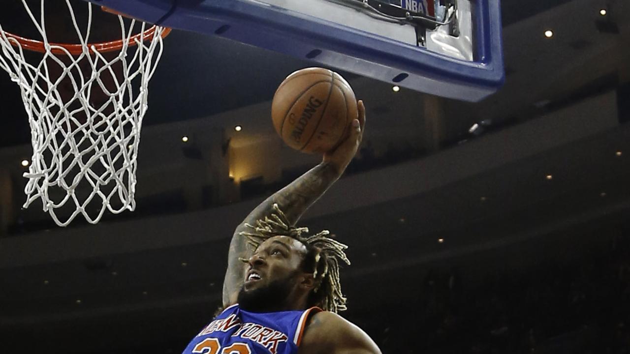 New York Knicks' Derrick Williams, right, goes up for a dunk against Philadelphia 76ers' Richaun Holmes during the first half of an NBA basketball game, Friday, Dec. 18, 2015, in Philadelphia. (AP Photo/Matt Slocum)