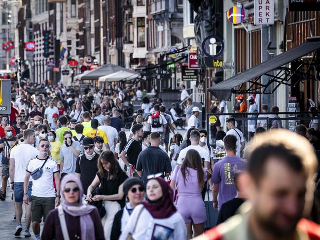 Tourists walk in the centre of Amsterdam as the Netherlands tighten up supervision of the measures to prevent the spread of the COVID-19. Picture: AFP