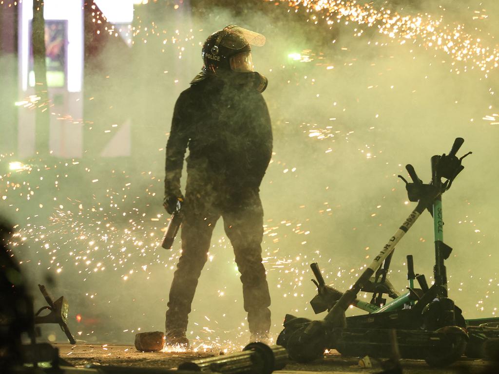 A police officer is seen standing amidst the incoming fireworks. Picture: Giorgi ARJEVANIDZE / AFP