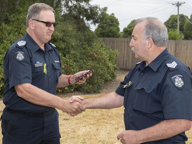 Senior Sergeant Glenn Parker presents a plaque to Sergeant Daryl Kennedy to mark 40 years in the force. Picture: Ellen Smith