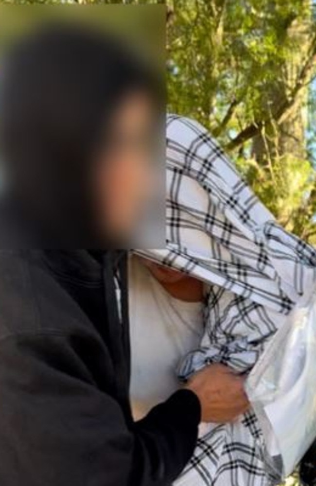 Nathan Bernhard leaving Nowra Police Station, hidden under blanket. Picture: Tom McGann