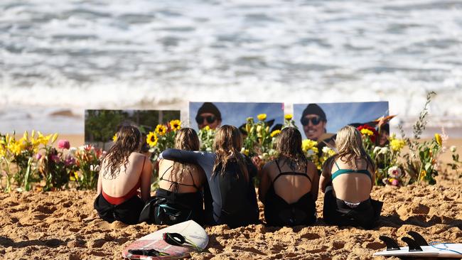 Friends pay their respects in memory of Alex 'Chumpy' Pullin at North Narrabeen Beach. Picture: Ryan Pierse/Getty Images