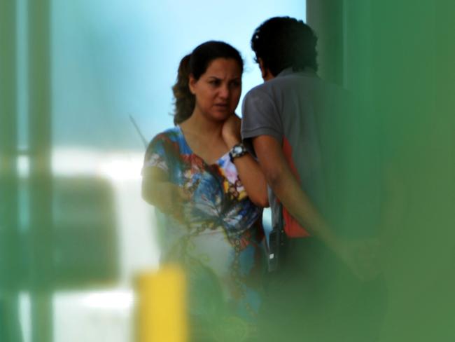 A pregnant woman who may be part of the family that did not get off a Detention Centre Bus for 36 hours talks with a security officer just metres from the bus.