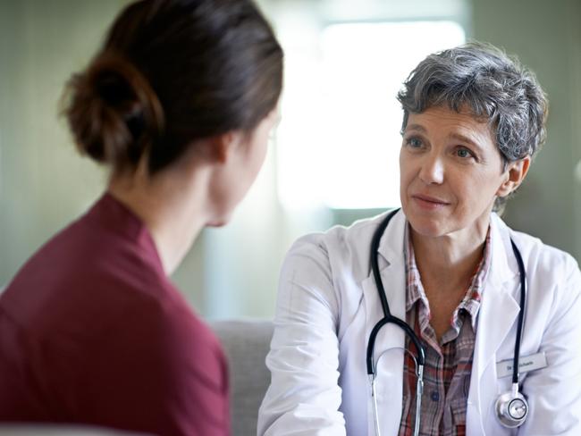 Shot of a compassionate doctor comforting a young woman in a hospital waiting room; fear health scare generic