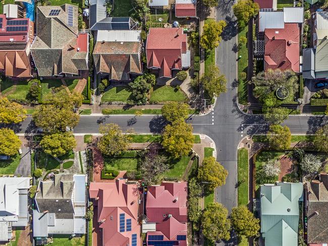 Aerial view of leafy eastern suburban houses on 4-way cross road intersection in Adelaide, South Australia: directly above, rooftop solar, trees. Housing property generic