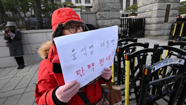 A woman supporting South Korea's President Yoon Suk Yeol holds a paper reading "Oppose the impeachment of President Yoon Suk Yeol!" in front of the Constitutional Court in Seoul. Picture: Jung Yeon-je / AFP