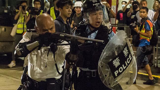 A police officer takes aim during a clash with protesters on Tuesday. Picture: AFP