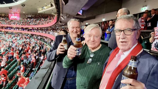 A toast to the champion: Andrew Ireland (from left), Richard Colless and Ricky Quade raise their beers after Lance Franklin kicked his 1000th goal at the SCG.