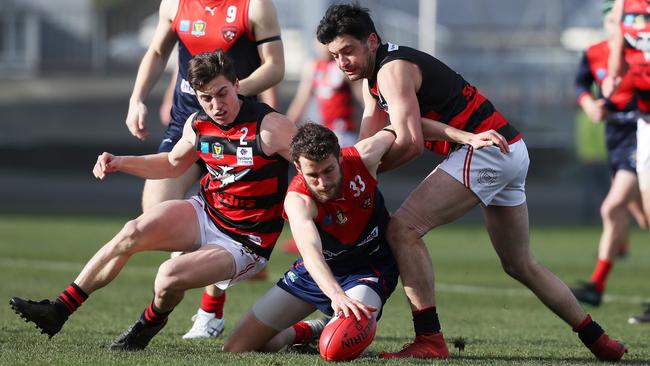 Matthew Yates (North Hobart) gathers under pressure from Lauderdale pair Joshua Williams (left) and Alex Hevey (right). Picture: NIKKI DAVIS-JONES