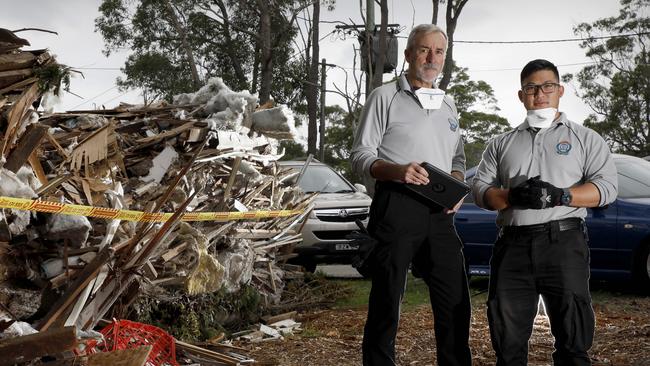 Rob Bradbury and Vinnie Truong from the Sydney Regional Illegal Dumping Squad investigate an illegal dumping site near Menai yesterday. Picture: Chris Pavlich