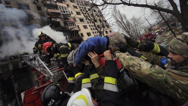 Rescuers workers carry an injured woman after the Russian attack in Kyiv on Monday. Picture: State Emergency Service of Ukraine