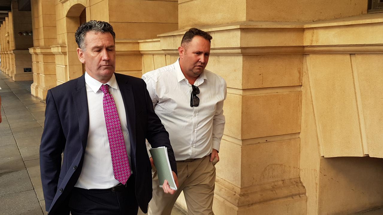 SA Ambulance Service officer Matthew James McLean, right, with no jacket, outside the District Court after his trial was vacated due to the COVID-19 pandemic. Picture: Sean Fewster