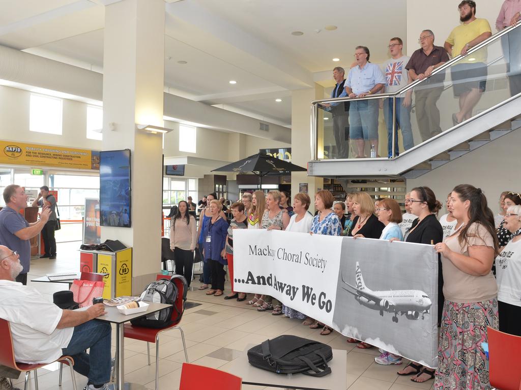 Jabin Mills left, conducts the Mackay Choral Society as they entertain travellers in the departure lounge of the Mackay Airport in 2015. Picture: Peter Holt