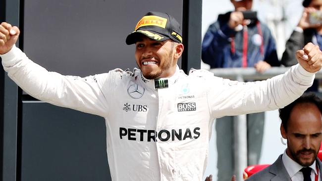 Lewis Hamilton of Great Britain and Mercedes GP celebrates his win on the podium.