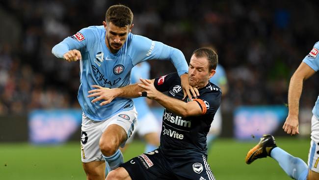 Melbourne Victory’s Leigh Broxham tackles Melbourne City’s Dario Vidosic on Friday night.