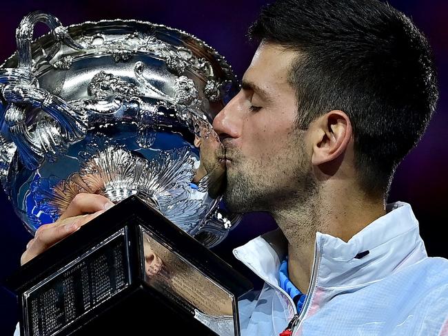 Serbia's Novak Djokovic celebrates with the Norman Brookes Challenge Cup trophy following his victory against Greece's Stefanos Tsitsipas in the men's singles final match on day fourteen of the Australian Open tennis tournament in Melbourne on January 29, 2023. (Photo by MANAN VATSYAYANA / AFP) / -- IMAGE RESTRICTED TO EDITORIAL USE - STRICTLY NO COMMERCIAL USE --