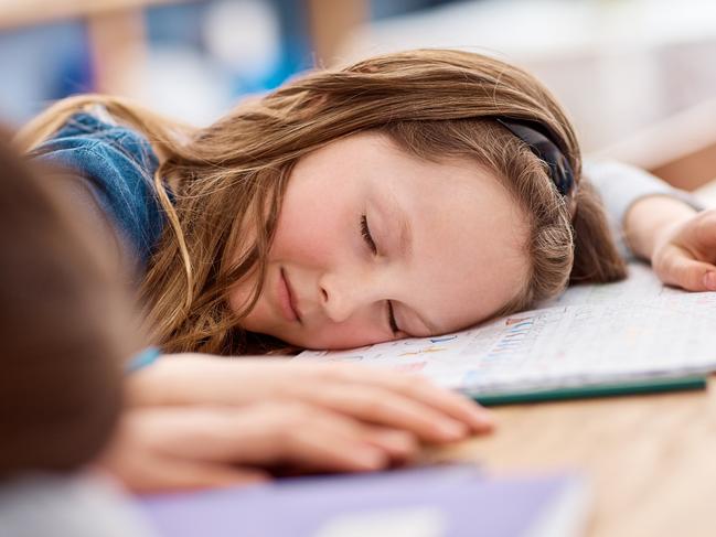 Shot of an elementary school girl sleeping on her desk in class