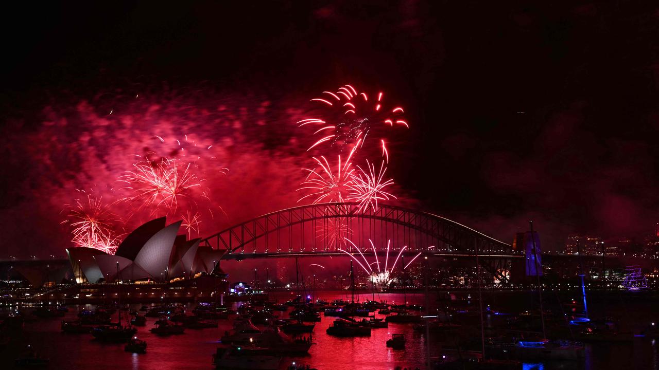 Fireworks explode high in the sky over Sydney Harbour Bridge. (Photo by Saeed KHAN / AFP)