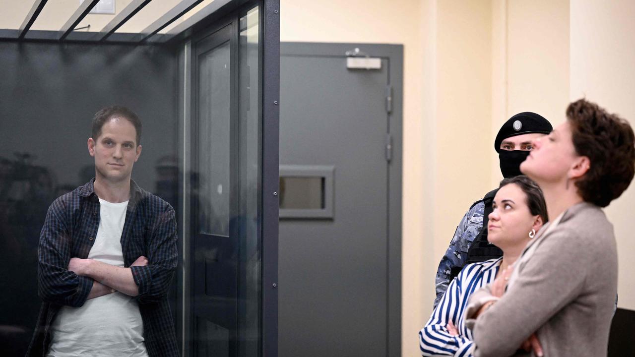 US journalist Evan Gershkovich, arrested on espionage charges, stands inside a defendants' cage next to his lawyers after a hearing to consider an appeal on his extended pre-trial detention. (Photo by Natalia KOLESNIKOVA / AFP)