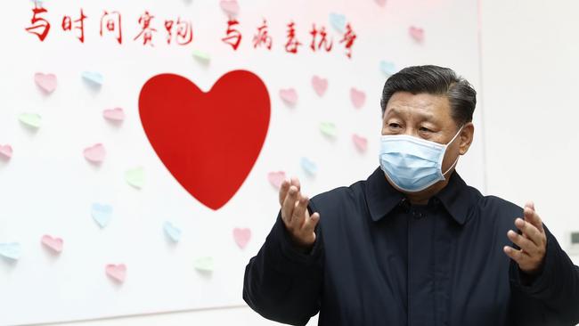 Chinese President Xi Jinping gestures near a heart-shaped sign and a slogan which reads “race against time, fight the virus” during an inspection of the centre for disease control and prevention in Beijing. Picture: AP