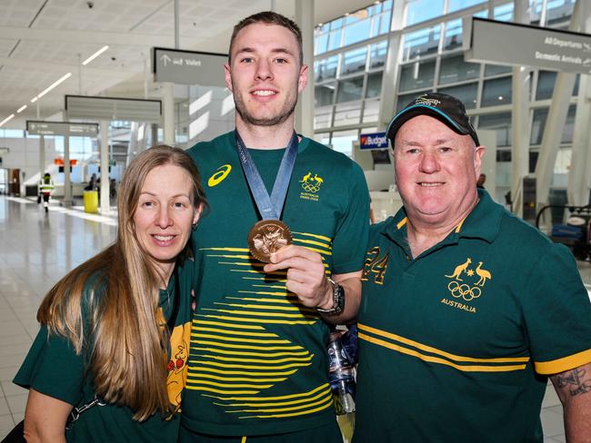 South Australian Olympic cyclist Leigh Hoffman with parents Kristen King and Rene Hoffman and his bronze medal at Adelaide Airport. Picture: NewsWire / Brenton Edwards