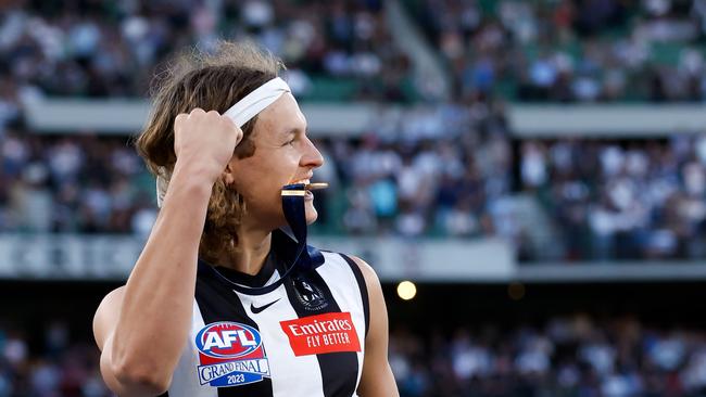 Jack Ginnivan of the Magpies celebrates after receiving his premiership medal.