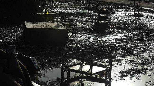 Destroyed furniture sits in the mud outside a home in Goodna in January 2011. Picture: Dean Lewins