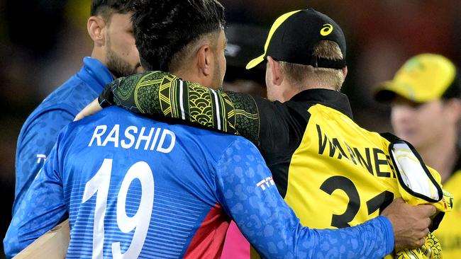 Australia's David Warner (R) embraces Afghanistan's Rashid Khan after the ICC men's Twenty20 World Cup 2022 cricket match between Australia and Afghanistan at Adelaide Oval on November 4, 2022 in Adelaide. (Photo by Brenton EDWARDS / AFP) / -- IMAGE RESTRICTED TO EDITORIAL USE - STRICTLY NO COMMERCIAL USE --