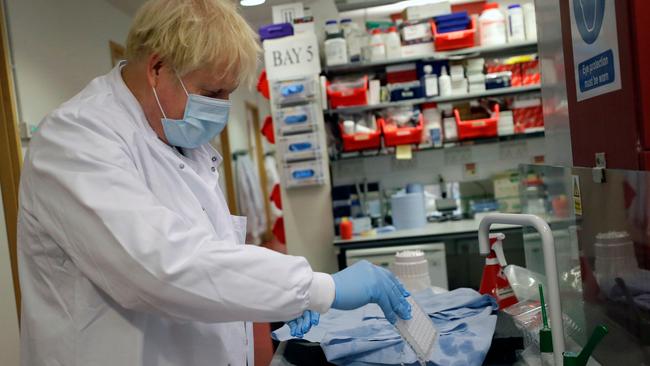 Britain's Prime Minister Boris Johnson washes immunologic assays during a visit to the Jenner Institute in Oxford, central England, where scientists are working on a vaccine. Picture: Kirsty Wigglesworth/AFP