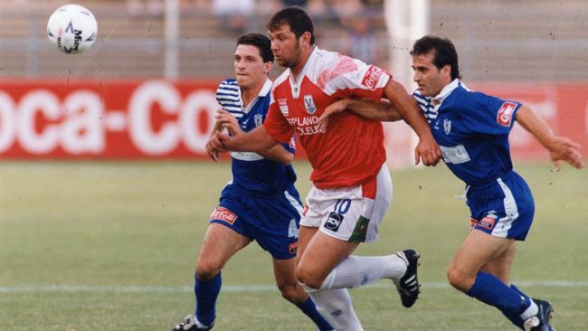 Morwell Falcons goalscorer John Markovski breaks through West Adelaide players Con Kokkinoplitis (l) and Lemmy Vatsilas at Hindmarsh Stadium on 25 Jan 1994 in the Coca-Cola National Soccer League.