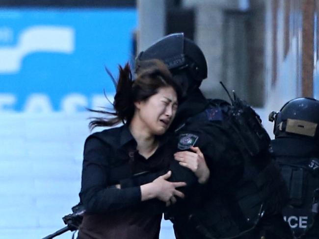 One of the hostages is helped by the tactical police after she escapes from the cafe. Picture: Adam Taylor