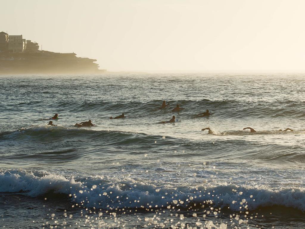 Surfers making there way out to sea to pay tribute to Annalise Braakensiek at the Memorial held at Bondi Beach around 7am Wednesday January 16 Image Picture: Monique Harmer