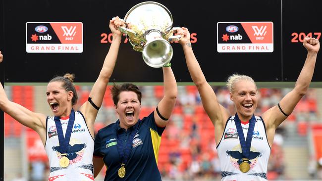 Adelaide Crows (L to R) Captain Chelsea Randall, coach Bec Goddard and co-Captain Erin Phillips hold the trophy aloft as they celebrate winning the AFLW Grand Final game against Brisbane Lions at Metricon Stadium in Carrara on the Gold Coast, Saturday, March 25, 2017. (AAP Image/Dan Peled) NO ARCHIVING, EDITORIAL USE ONLY