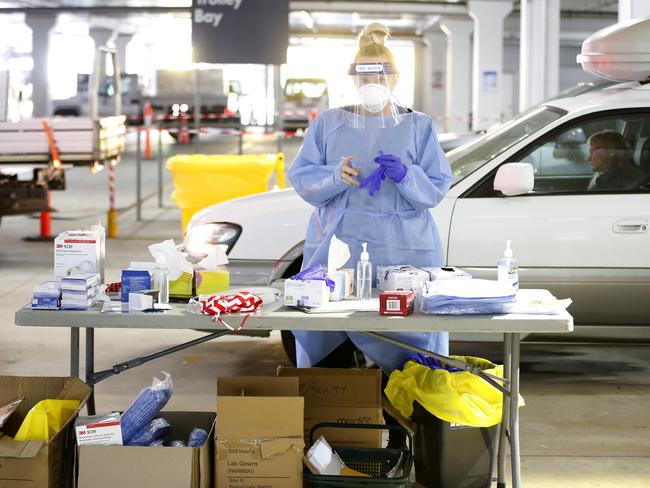 A medical worker prepares to administer a test on a member of the public at a drive through testing clinic in the carpark of Bunnings in West Footscray. Picture: Getty Images.