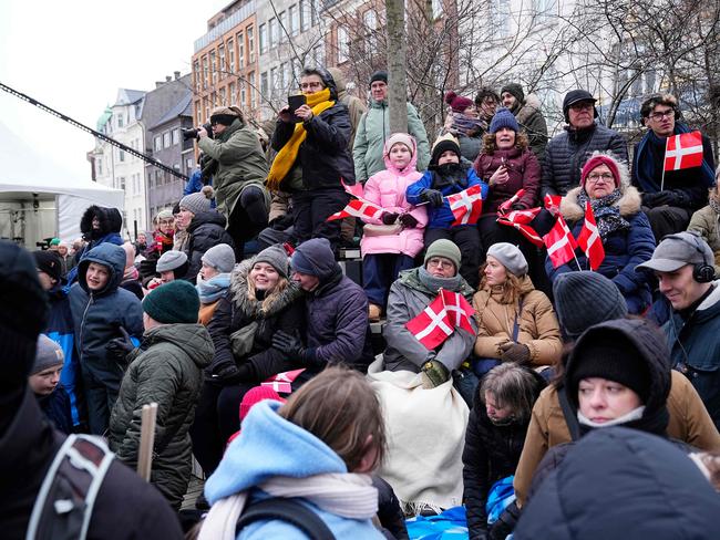 Wellwishers wait outside Aarhus Cathedral with Danish flags. Picture: AFP