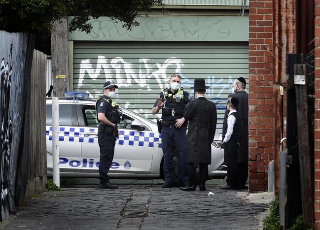 Police speak to locals near an alleged illegal gathering at a synagogue in Ripponlea. Picture: Andrew Henshaw